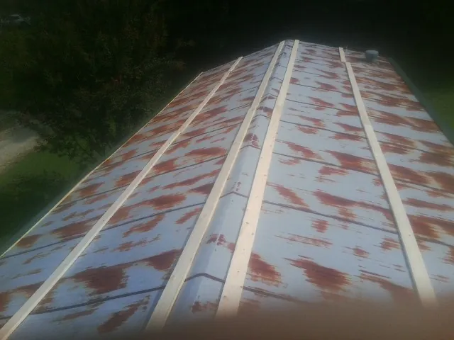 Rusted metal roof panels with new wood purlins before replacement — Storm Damage Roof Repair in Cambridge by Roofing Brothers
